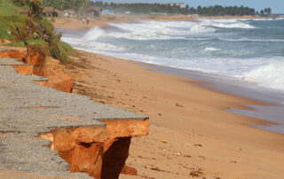 Avepozo, Togo - October 25, 2018: Eroded beach with an asphalt road washed away by the sea in Avepozo, Togo, West Africa.