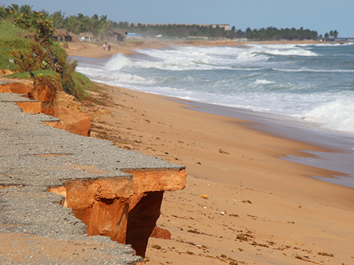 Avepozo, Togo - October 25, 2018: Eroded beach with an asphalt road washed away by the sea in Avepozo, Togo, West Africa.